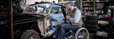 Manual wheelchair XLT Max blue frame man working on a car