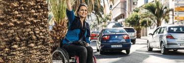 Manual wheelchair Küschall Champion red frame woman catching taxi