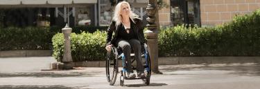 Manual wheelchair Küschall Compact black frame woman on the street