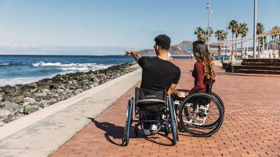 Manual wheelchair K-Series couple in front of ocean